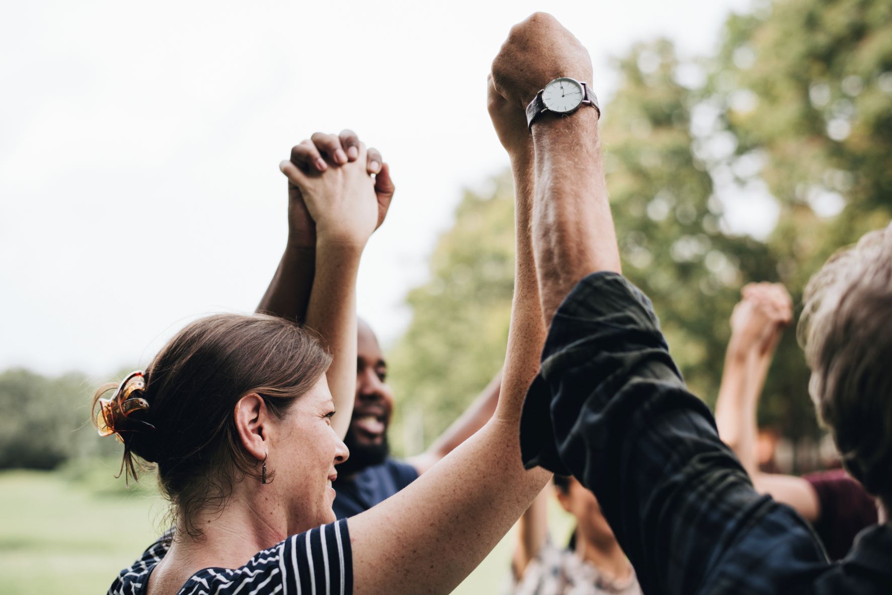 Group of people raising linked hands