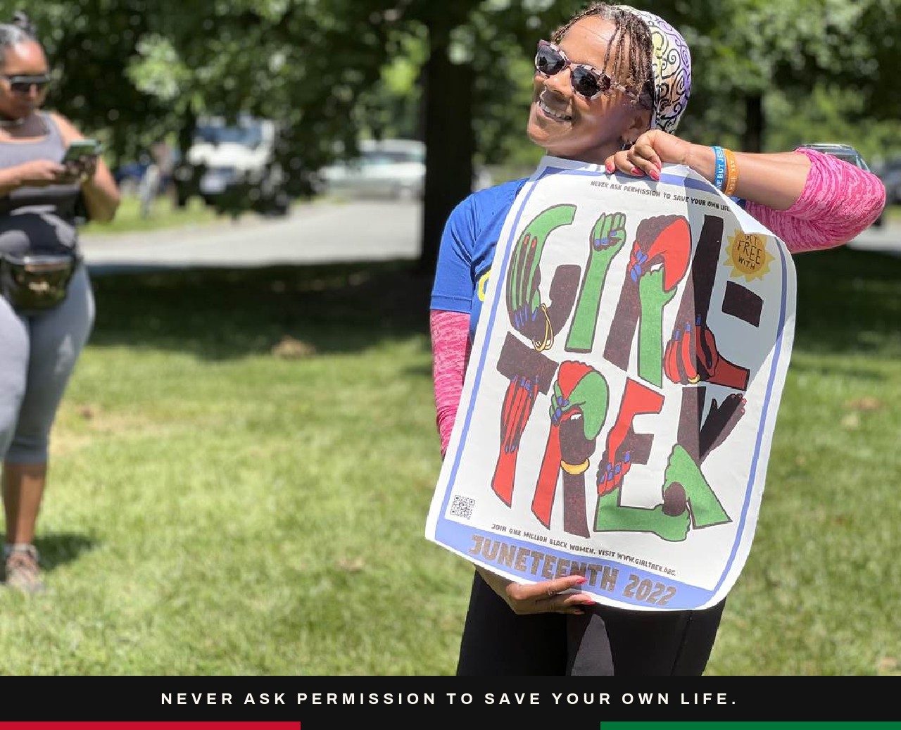 A GirlTREK member holding a Juneteenth poster.