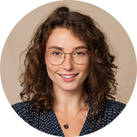 A headshot of a female who is smiling and wearing glasses.