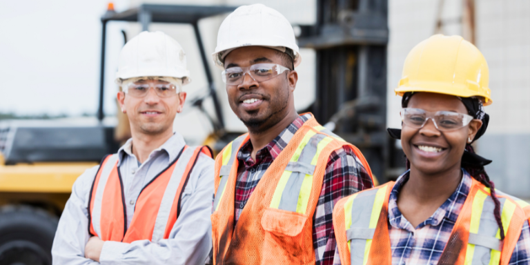 Three people in safety gear at a construction site Three people in safety gear at a construction site