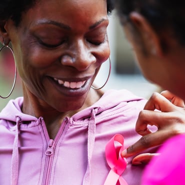 Persona recibiendo un lazo de concientización sobre el cáncer de mama