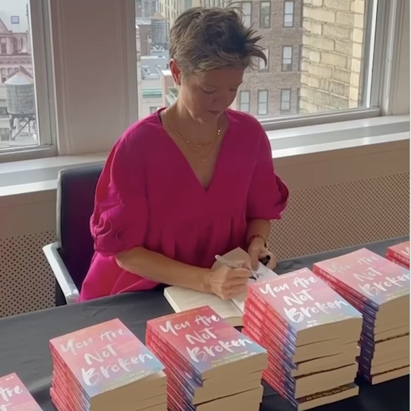 Photo of Kelly Casperson autographing books