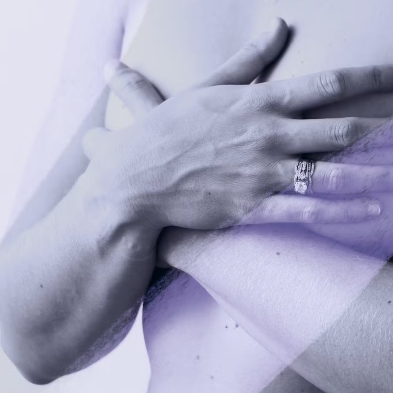 Close-up photo of a woman covering her breasts