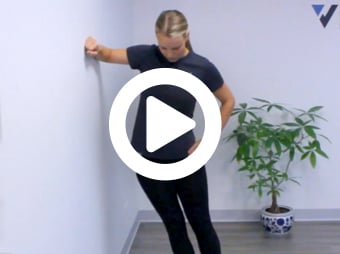 Video still featuring physical therapist performing a hip stretch