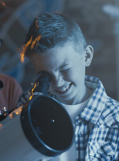 Kid looking through telescope
