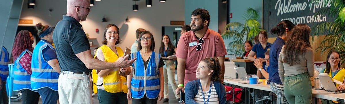Shelter employees in vests assisting handicapped person