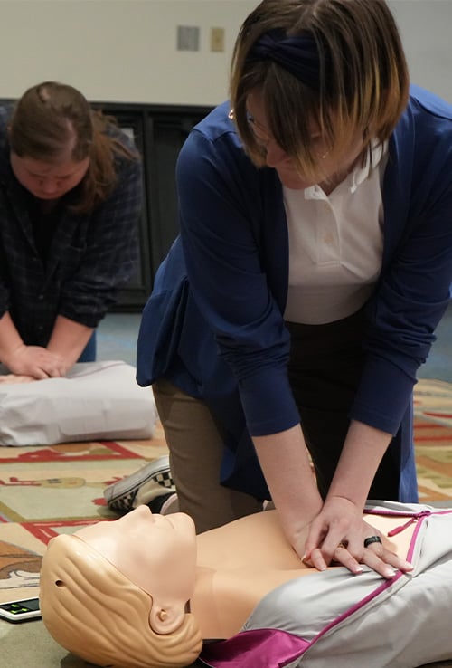 Person practicing CPR on a dummy