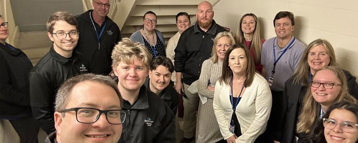 group of employee posing under stairwell during tornado drill group of employee posing under stairwell during tornado drill