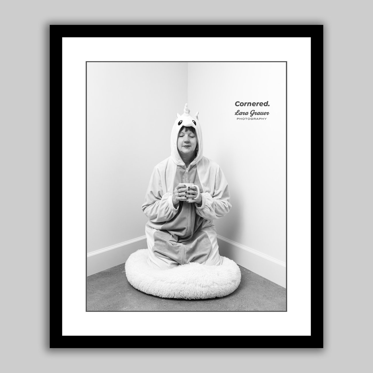 Cornered Project - Doris with her eyes closed dressed in a unicorn costume and holding a mug