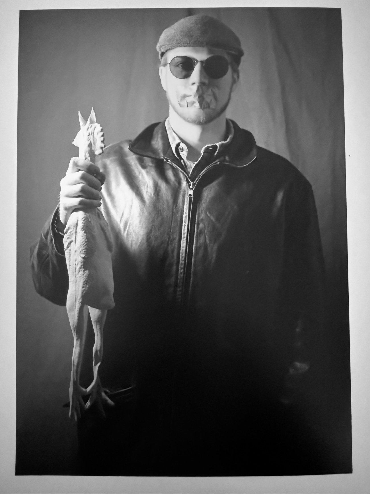 Rubber Chicken Project - Man wearing sunglasses with duct tape over his mouth and holding a rubber chicken