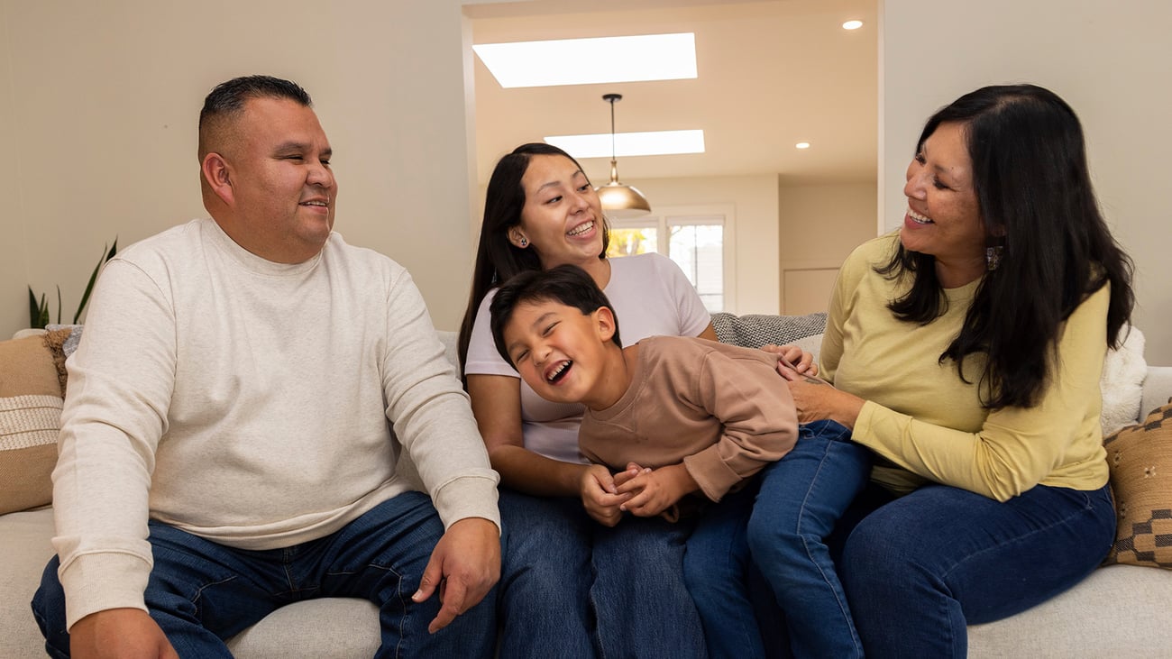 Portrait of a two adult and two child family, smiling and laughing outside