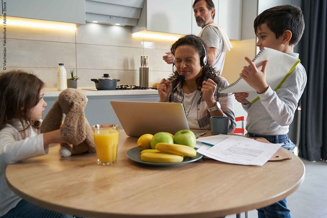 Woman trying to work on laptop and becoming stressed by children interupting