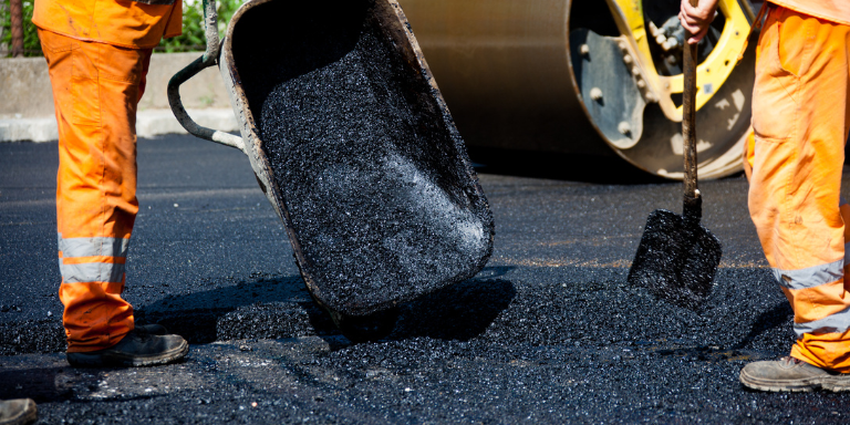 Construction workers paving a road