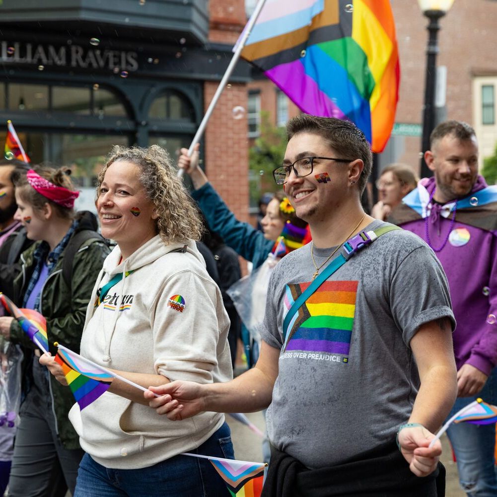 Homem e mulher marchando na Parada do Orgulho 