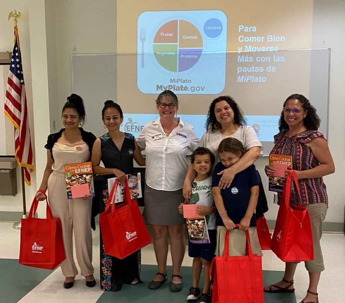 EFNEP Nutrition Educator, Angie Lawrence, stands in the middle of some participants of the EFNEP program.