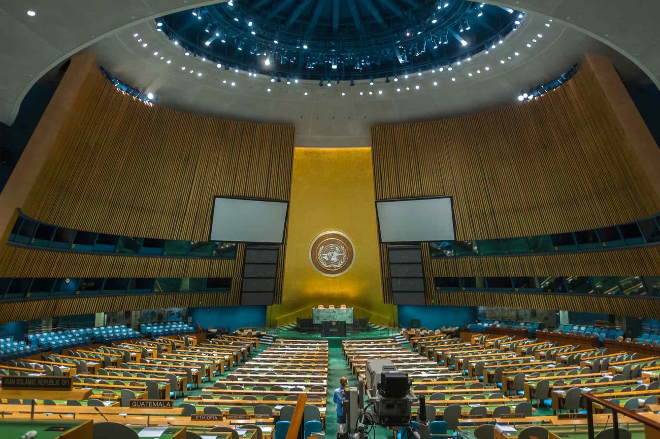 Wideshot photograph of the General Assembly Meeting Room at UN headquarters.