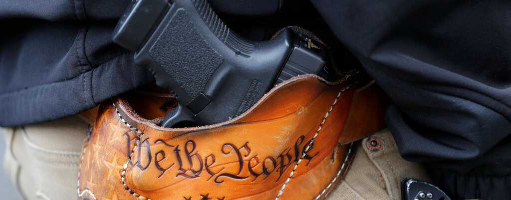 An attendee at a gun rights rally carries his gun in a holster that reads 'We the People,' on January 18, 2019, at Olympia, Washington.