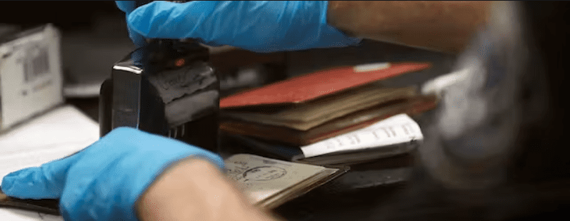 A U.S. Customs and Border Protection officer stamps a passport at Dulles International Airport in Virginia, March 13, 2020. Glenn Fawcett via Wikimedia Commons