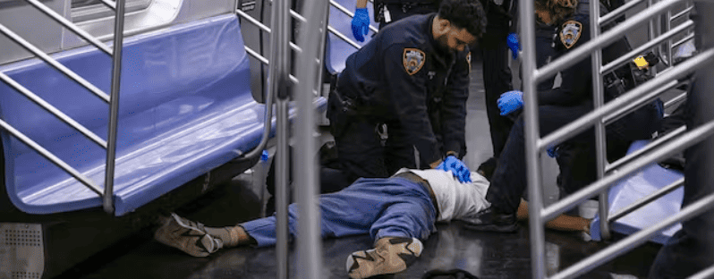 New York police officers administer CPR to a man at the scene where a fight was reported on a subway train Monday. Paul Martinka via AP