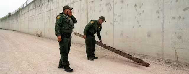 U.S. Border Patrol agents pick up a ladder that migrants carried to the border wall near the port of entry at Hidalgo, Texas, May 4, 2023. AP/Veronica G. Cardenas, file