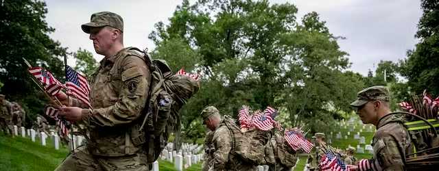 Members of the 3rd U.S. Infantry Regiment, also known as the Old Guard, place flags in front of each headstone at Arlington National Cemetery on May 25, 2023. AP/Andrew Harnik