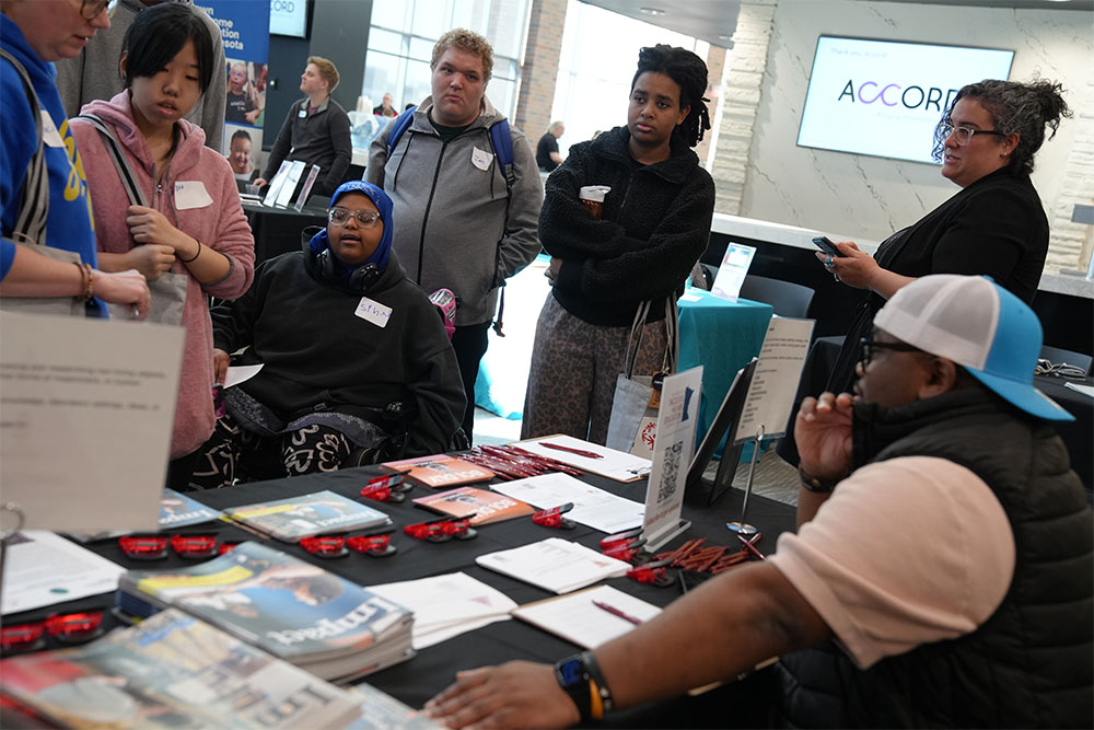 Dupree Edwards (seated at right) from the Institute on Community Integration assists young job seekers with disabilities at the Inclusive Career & Resource Fair at the University of Minnesota in March 2026.