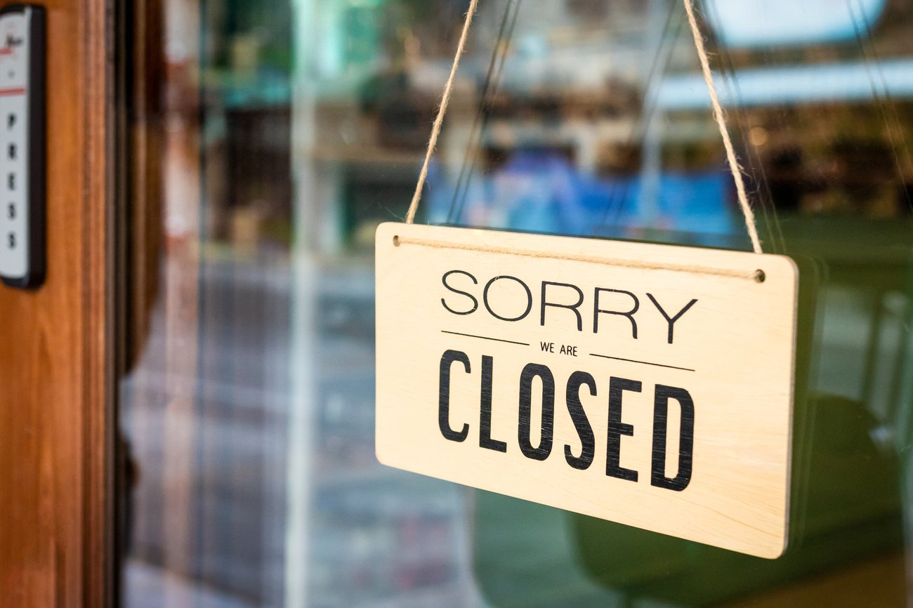wooden sign on restaurant door reading Sorry Closed