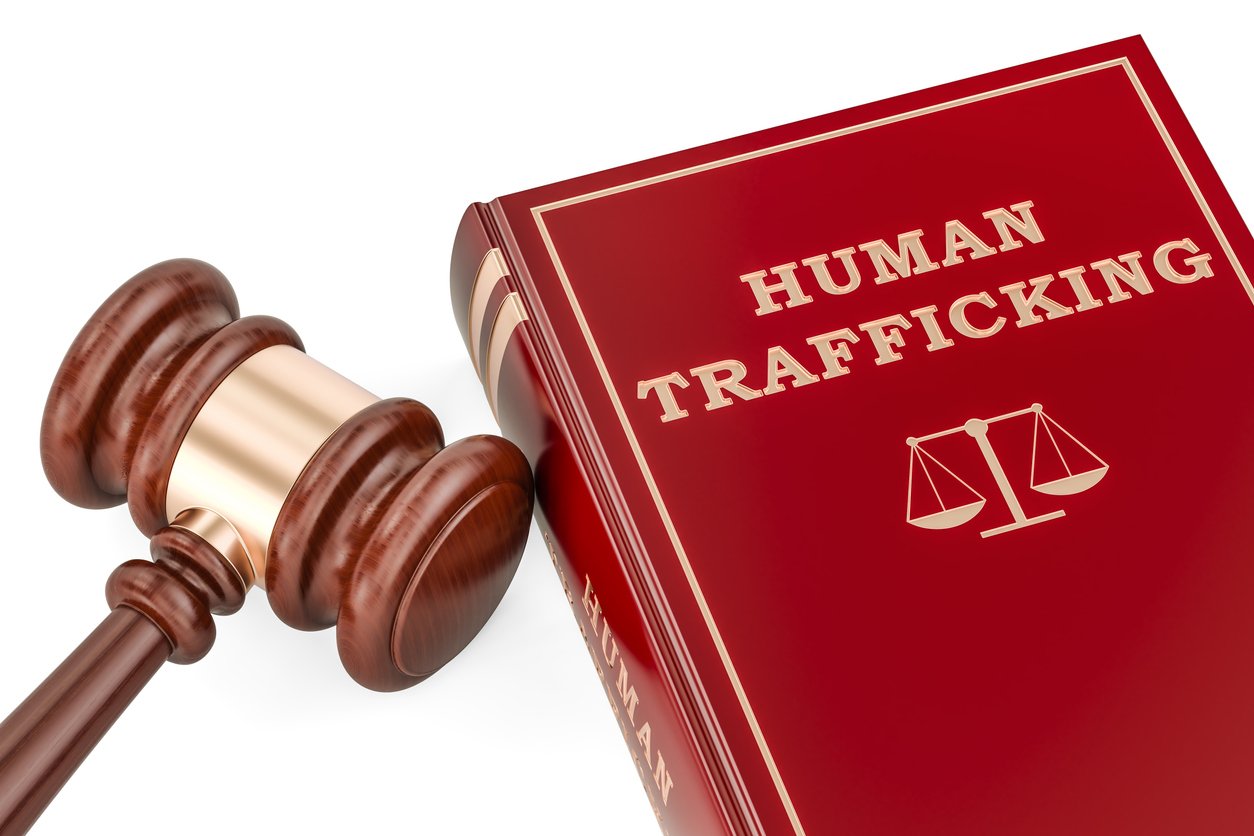 red book titled Human Trafficking next a brown judge's gavel