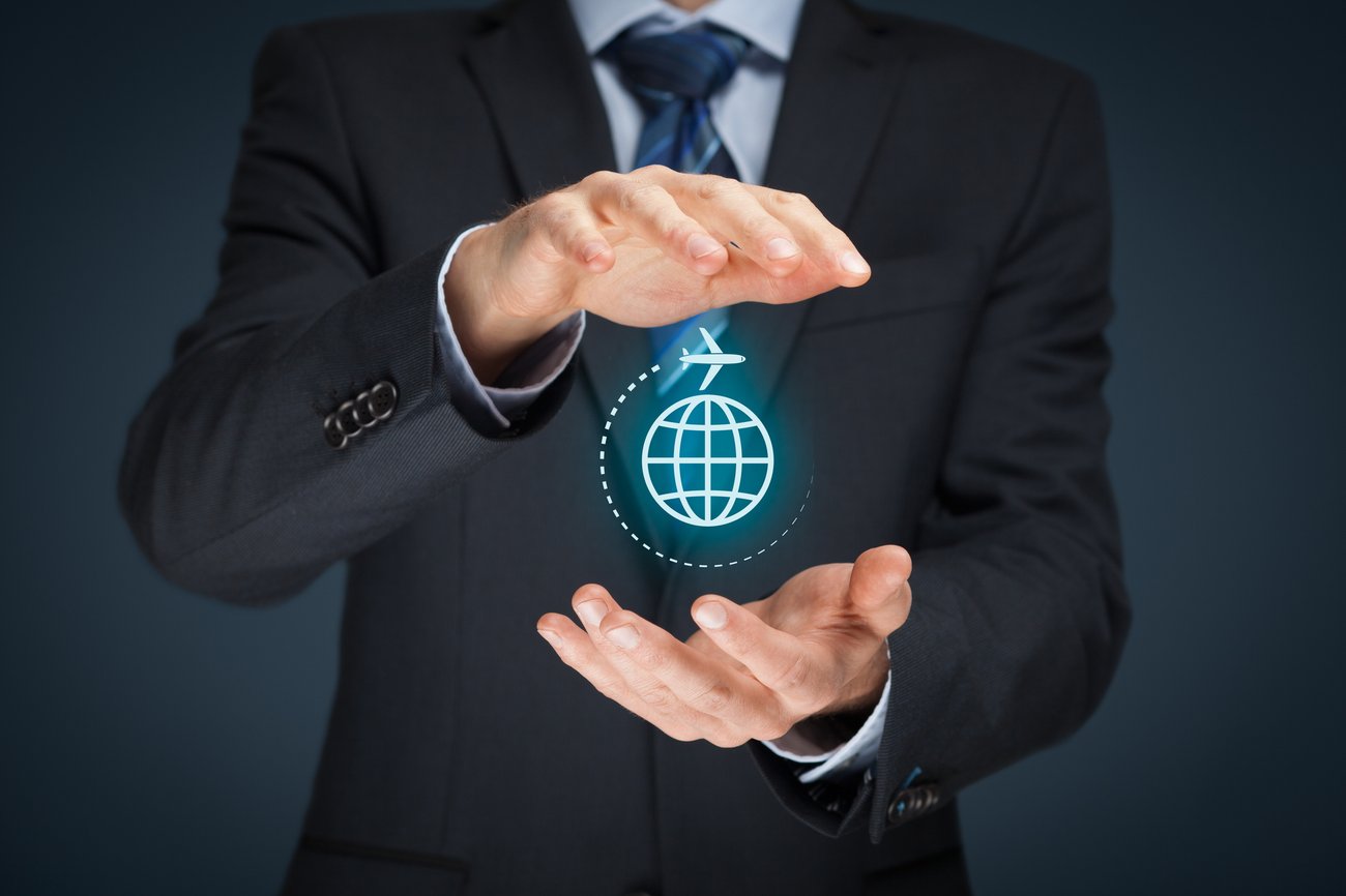 businessman holding digital earth with an airplane circling between his hands