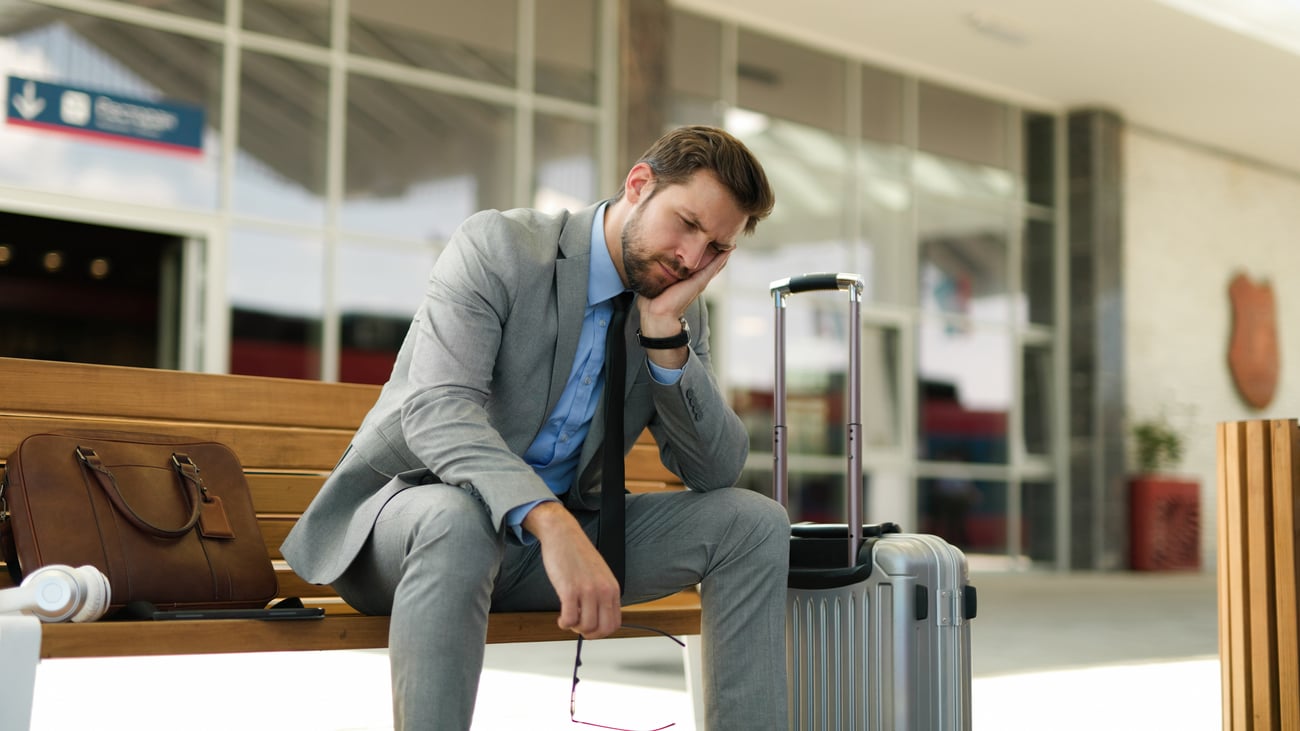 Frustrated Business man with luggage waiting for train