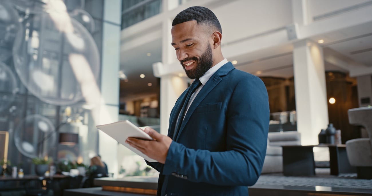 Businessman, digital tablet or strategy planning in hotel
conference lobby or airport travel lounge. Happy smile, corporate worker or technology app to budget company finance or schedule target goals