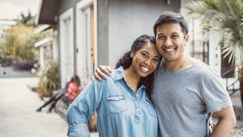 Smiling and hugging couple with coffee in their hands