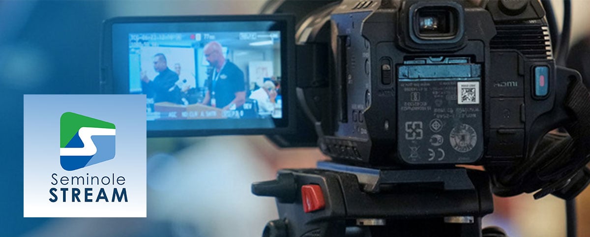 Close-up shot of video camera filming an interview with Alan Harris.