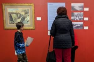 kid and adult at museum looking at paintings