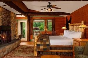 guest room with bed and fire in fireplace