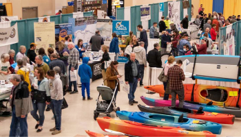 people walking around an indoor summer sports expo