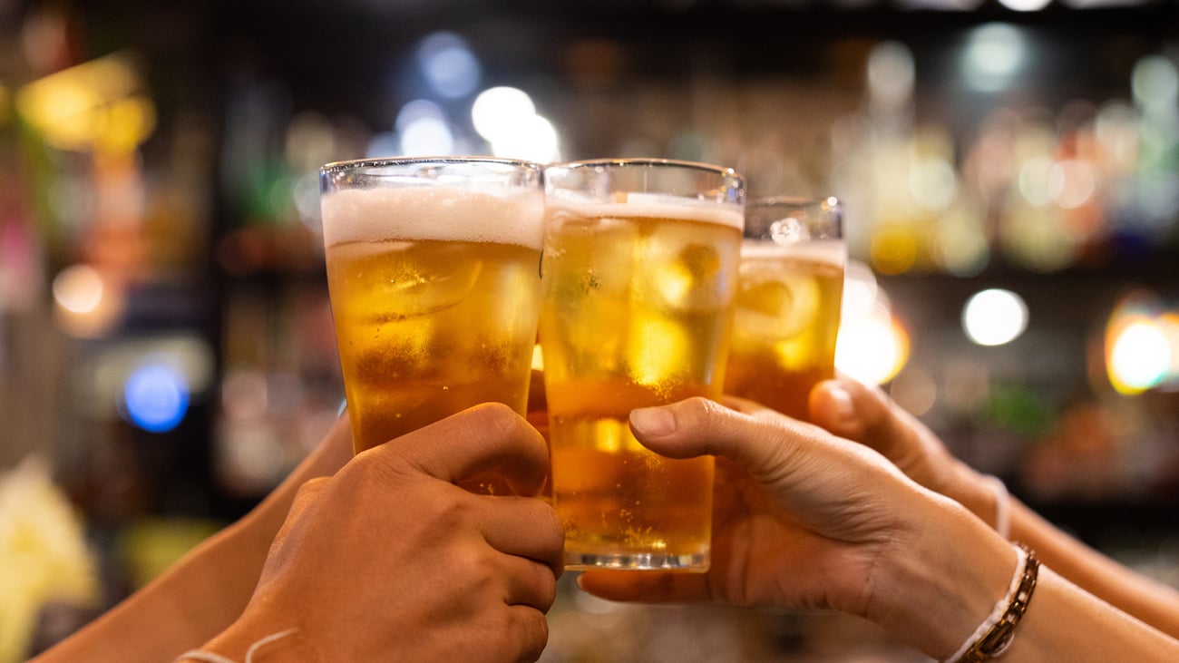 Hands holding up beer glasses in a cheers