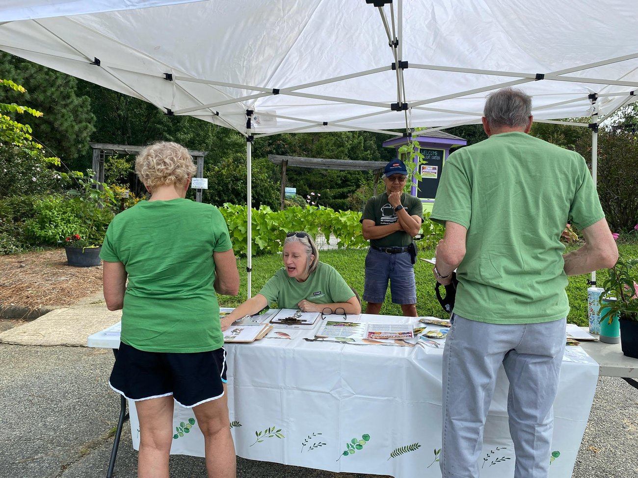Photo from NC Cooperative Extension Guilford County Center Open House. People conversing and visiting information tables in the lobby. 