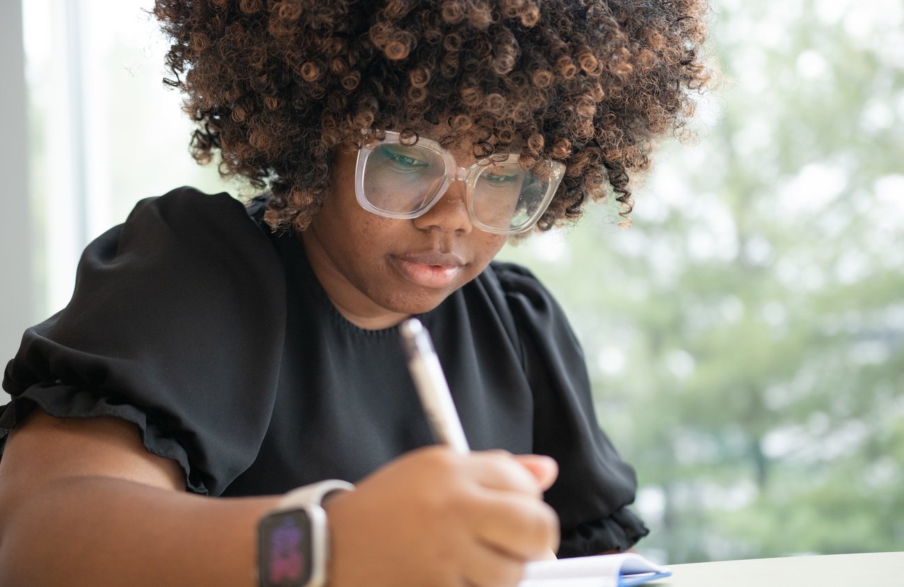 A young woman writes in a school setting