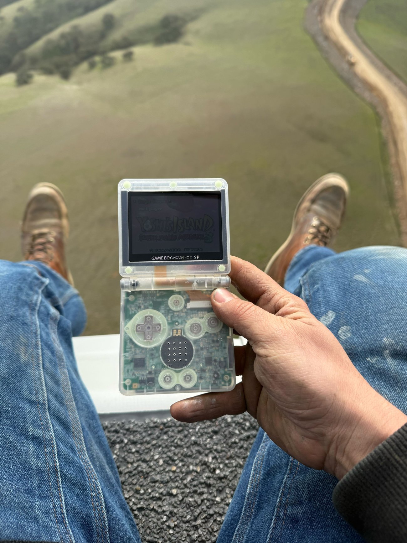 Image: Community member holds his newly refurbished Game Boy Advance SP from the top of a wind turbine
