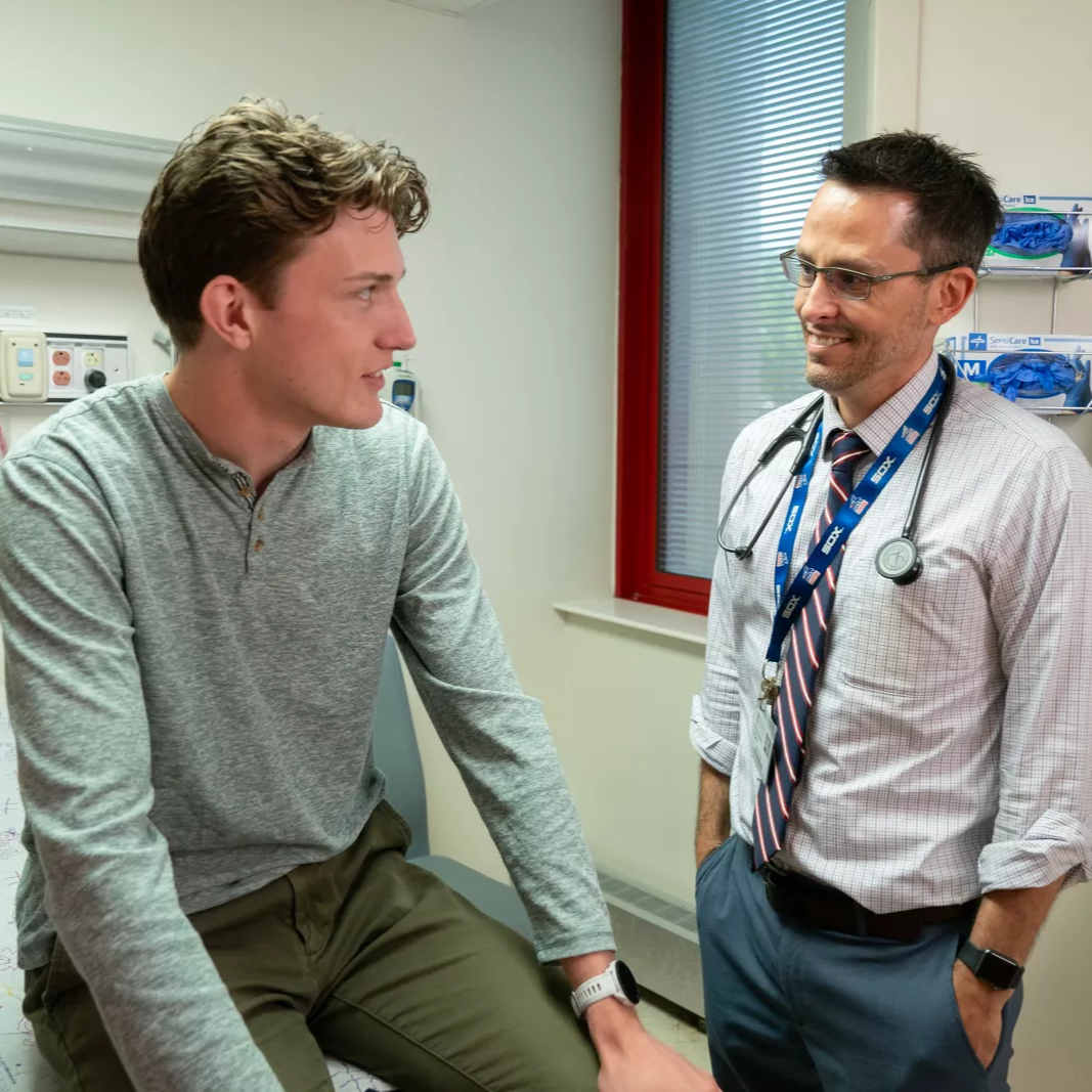 young man and doctor talking while in an exam room