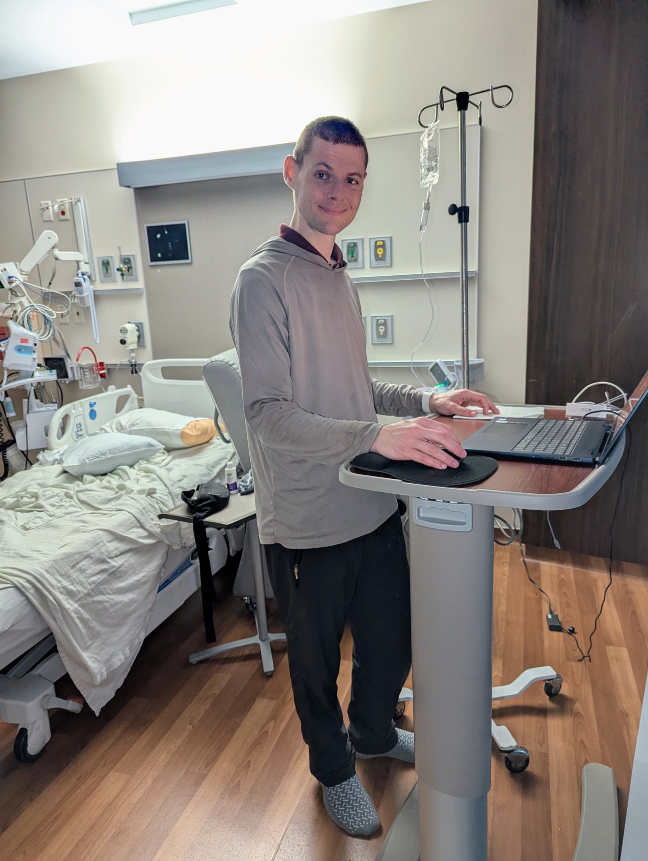 photo of Gleb working on his laptop in a hospital room
