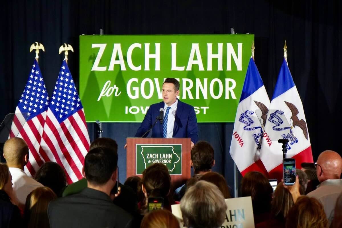 Zach Lahn stands before a crowd, backed by a sign for his gubernatorial race.
