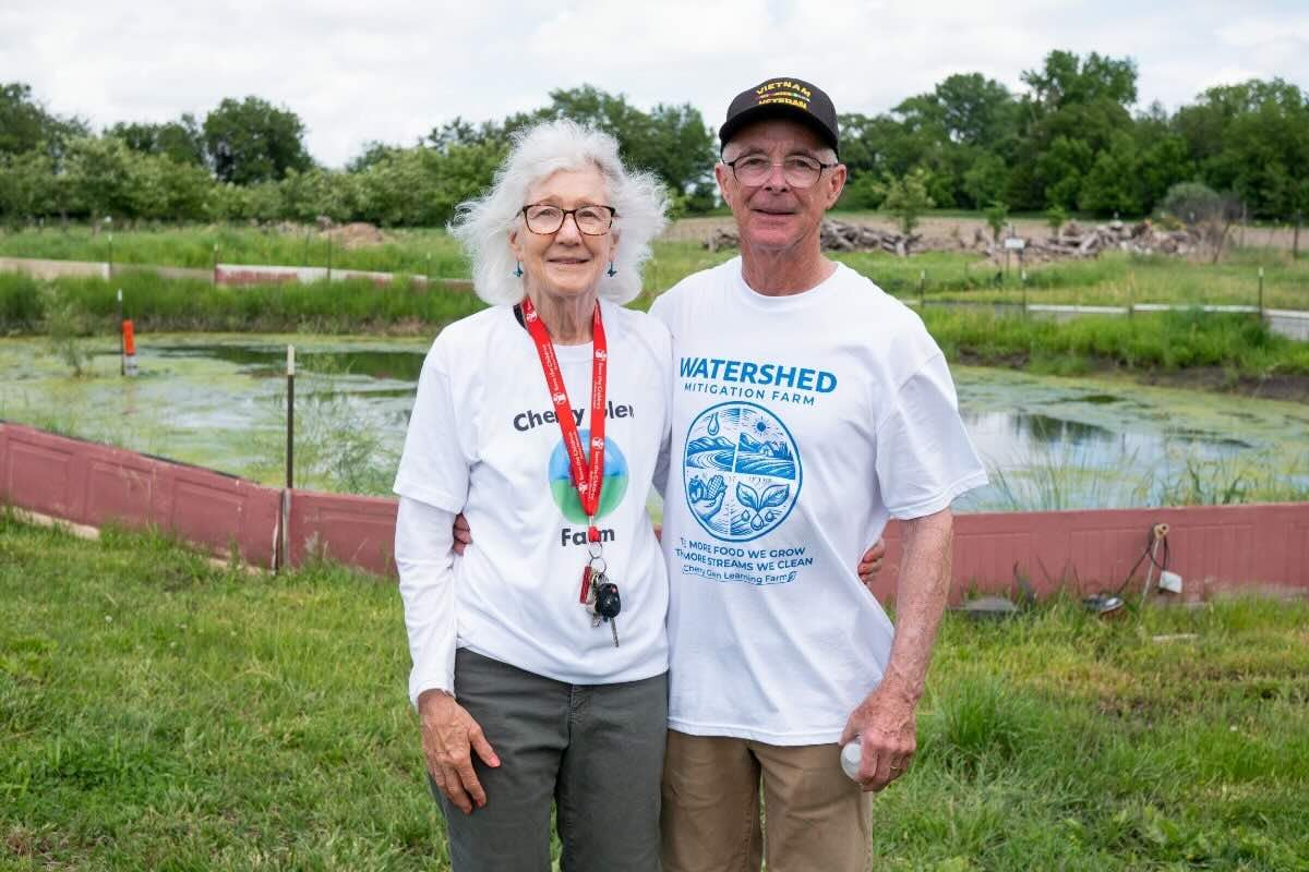 Ray and Susan Meylor, owners of Cherry Glen Learning Farm, stand in front of their water retention basin, which they use for solar-powered irrigation.