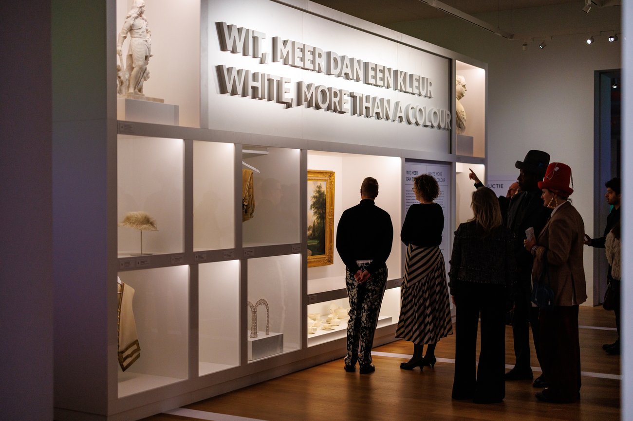 Visitors view illuminated displays and artwork in a museum exhibition