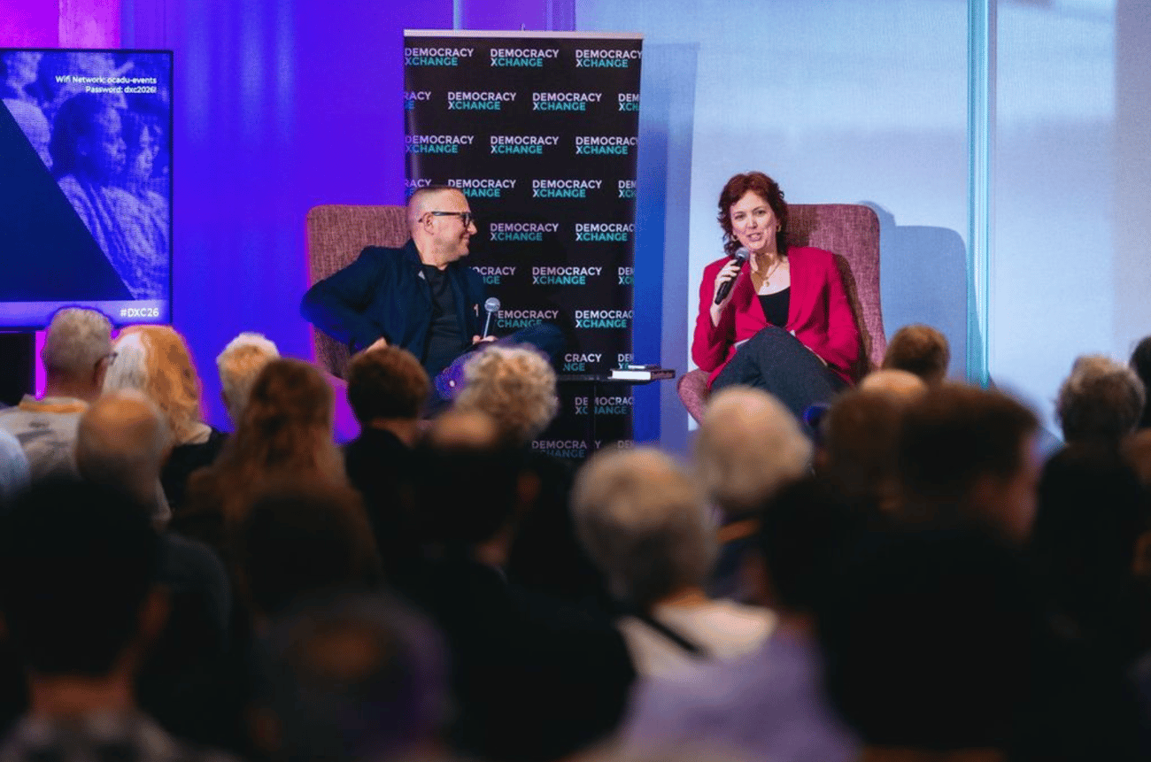 A photo from DemocracyXChange 2026 with the Walrus Executive Director Jennifer Hollett and author and activist Cory Doctorow seated in conversation onstage. A photo from DemocracyXChange 2026 with the Walrus Executive Director Jennifer Hollett and author and activist Cory Doctorow seated in conversation onstage.