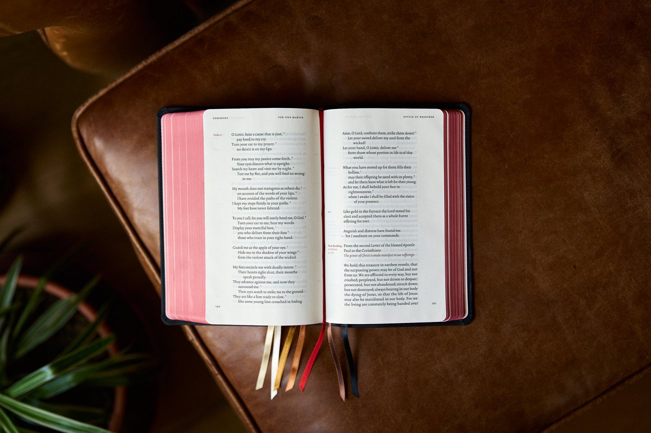 An open Bible with colorful ribbons resting on a brown leather surface An open Bible with colorful ribbons resting on a brown leather surface