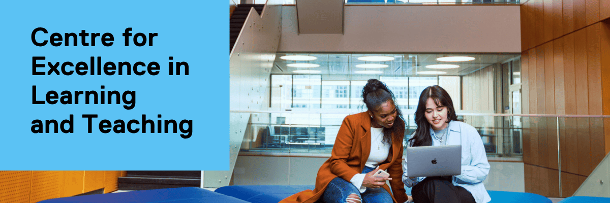 Two women sitting down and looking at a laptop.