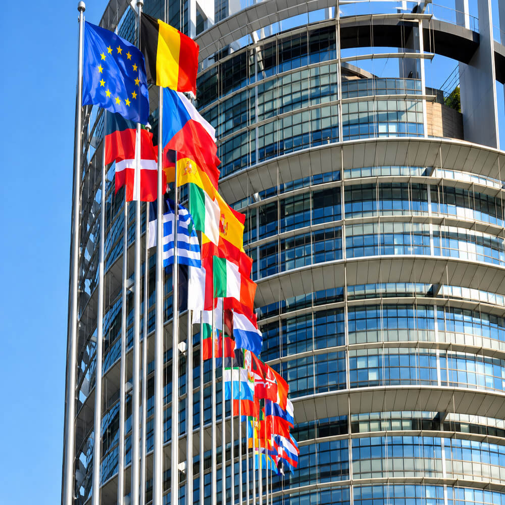 European flags flying outside a modern glass building