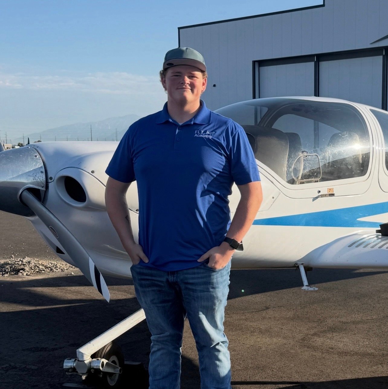 A person standing beside a small airplane outdoors